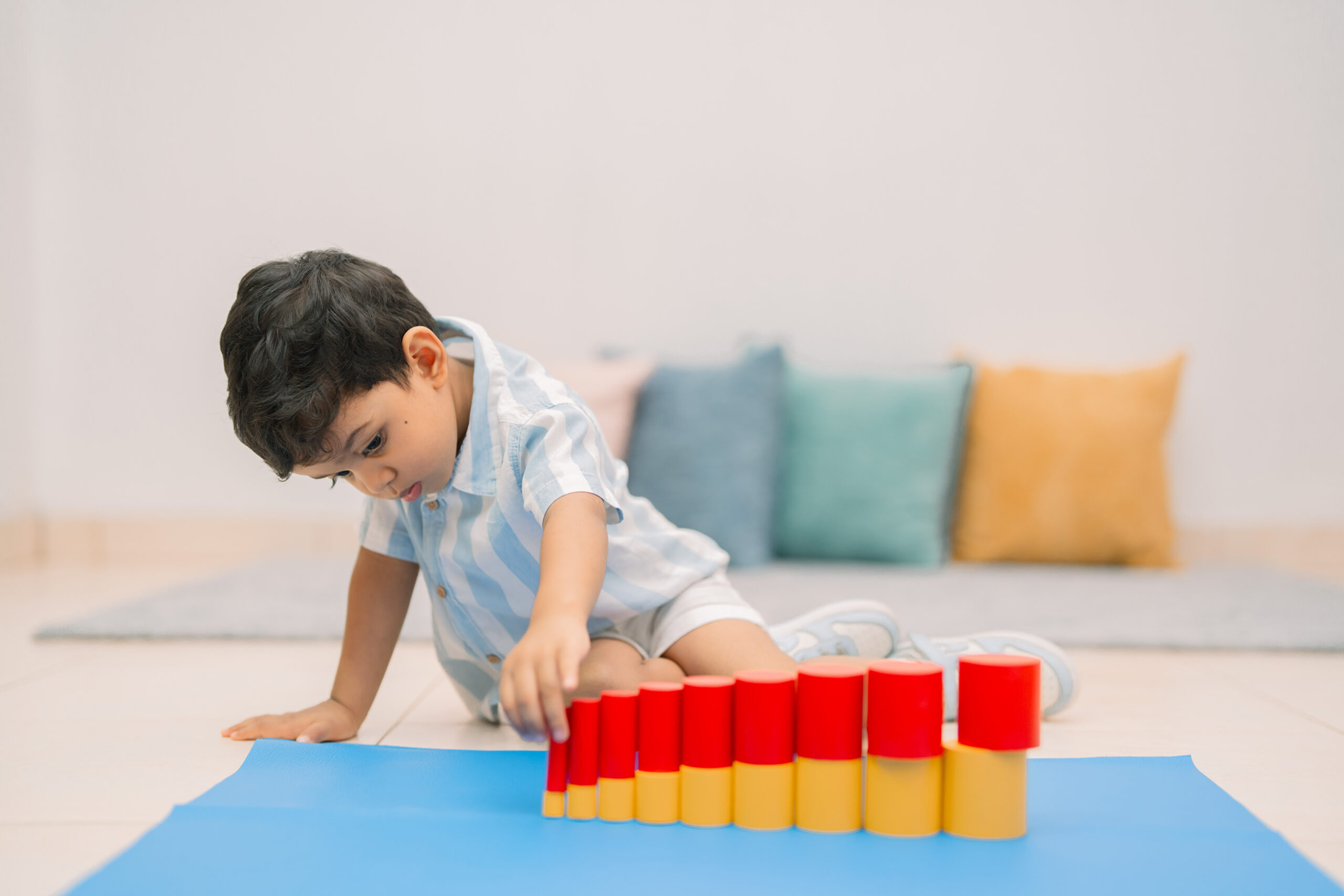 A child at a table working with wooden Montessori materials